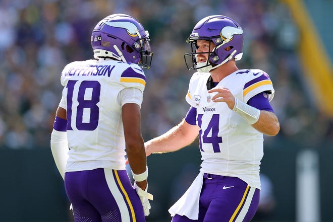 GREEN BAY, WISCONSIN - SEPTEMBER 29: Justin Jefferson #18 and Sam Darnold #14 of the Minnesota Vikings celebrate a touchdown against the Green Bay Packers during the first quarter of the game at Lambeau Field on September 29, 2024 in Green Bay, Wisconsin. (Photo by Stacy Revere/Getty Images)