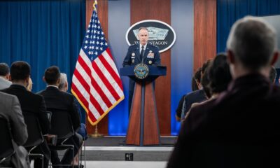 A man speaks from a podium to an audience.