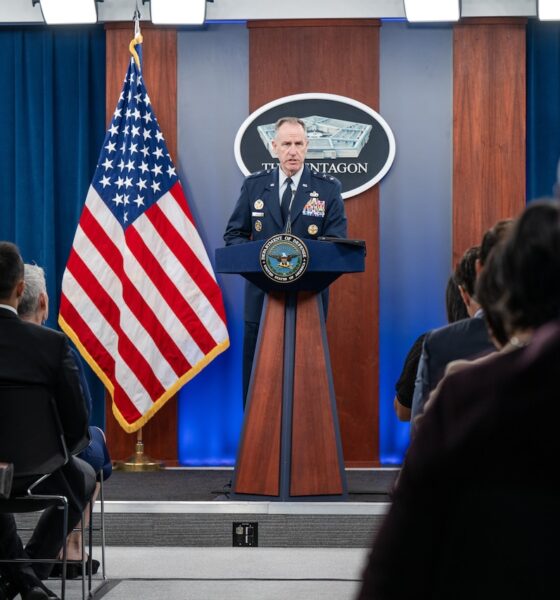 A man speaks from a podium to an audience.