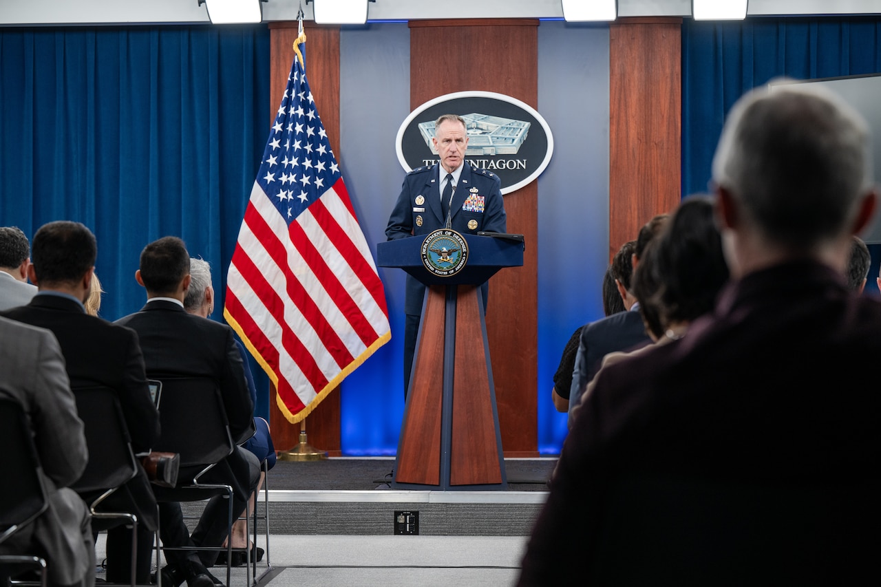 A man speaks from a podium to an audience.