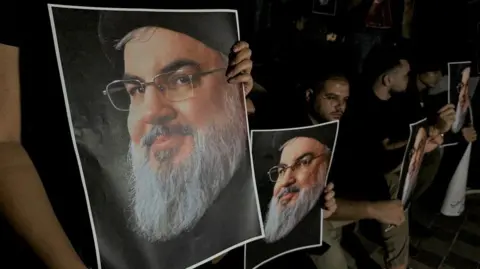 Reuters Supporters of Lebanon's Hezbollah leader Hassan Nasrallah carry his pictures as they gather in Sidon, Lebanon, following his killing