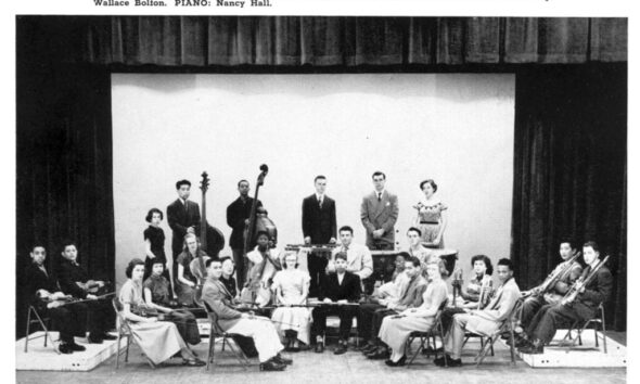 Quincy Jones sits with trumpet along with other students with instruments in the orchestra