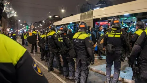 EPA-EFE/REX/Shutterstock Dutch riot police in Amsterdam throw a security cordon around a bus carrying Maccabi Tel Aviv fans