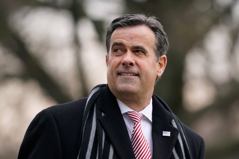 A December 2020 file photo shows John Ratcliffe, then the U.S. director of national intelligence, waiting to board a helicopter on the South Lawn of the White House in Washington.