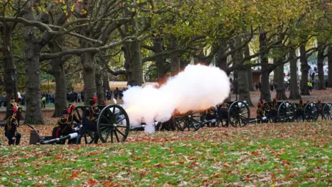 PA Media Soldiers of the King's Troop Royal Horse Artillery in ceremonial uniform fire a 41-gun salute from horse-draw guns at Green Park in central London. Smoke can be seen coming from the muzzle of one of the six guns seen in this photograph