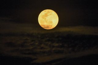 The bright full moon over wispy clouds in singapore