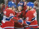 Canadiens Joel Armia, left, Nick Suzuki, second from left, and Mike Matheson, right, celebrate with teammate Jake Evans after his empty net goal sealed a victory against the Oilers Monday night at the Bell Centre.