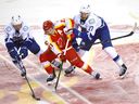 Abbotsford forward Max Sasson (27) battles Matthew Phillips of Calgary during AHL playoffs at the Saddledome on April 26, 2023.