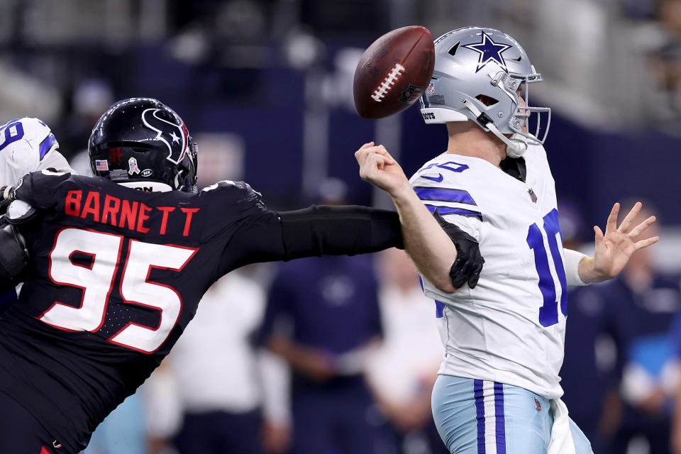 ARLINGTON, TEXAS - NOVEMBER 18: Cooper Rush #10 of the Dallas Cowboys fumbles the ball against Derek Barnett #95 of the Houston Texans during the fourth quarter in the game at AT&T Stadium on November 18, 2024 in Arlington, Texas. (Photo by Sam Hodde/Getty Images)