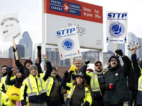 Canada Post workers man the picket line at the Bridge sorting station in Montreal on Nov. 18.