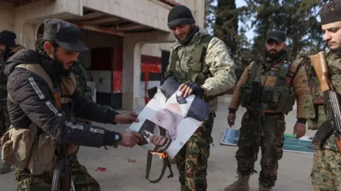 AFP Fighters set alight a picture of Syrian President Bashar al-Assad in front of a building that was seized by jihadists in the area of Zarbah on November 29, 2024,