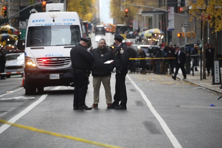 Wide shot of police on a road adjacent to the Hilton Hotel in Midtown Manhattan where United Healthcare CEO Brian Thompson was fatally shot 