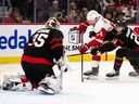 Senators defenceman Jacob Bernard-Docker, right, tries to force Red Wings forward Tyler Motte away from the net as he tries to backhand the puck at Ottawa goaltender Linus Ullmark in the first period of Thursday night's NHL game.