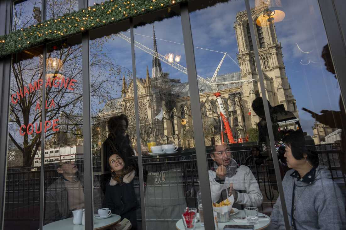 Customers sit inside a restaurant next to France's iconic Notre Dame Cathedral, hours before formally reopening its doors for the first time since a devastating fire nearly destroyed the 861-year-old landmark in 2019, on Saturday, Dec. 7, 2024, in Paris. (AP Photo/Bernat Armangue)