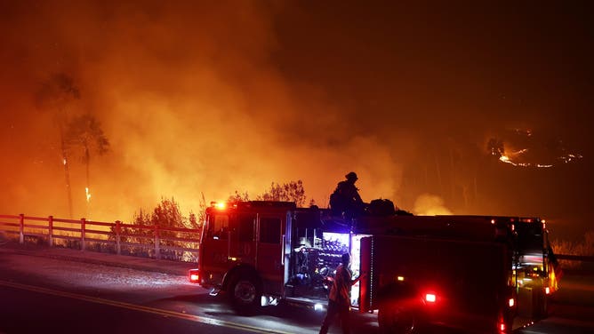 MALIBU, CALIFORNIA - DECEMBER 10: Firefighters work as the Franklin Fire burns on December 10, 2024 in Malibu, California. The wildfire has scorched 1,800 acres near Pepperdine University prompting evacuations along the coast amid high winds with some structures destroyed. (Photo by Mario Tama/Getty Images)