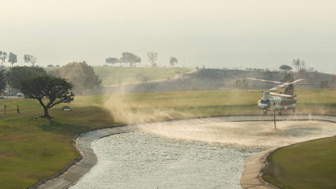 A Ventura County fire helicopter picks up water from a pond at Pepperdine University while fighting the Franklin fire in Malibu, CA on Tuesday, Dec. 10, 2024.