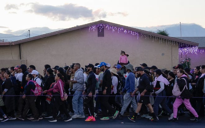 Hundreds of people walk in the Virgen de Guadalupe pilgrimage through the Coachella Valley as it passes through Indio, Calif., just before sunset Dec. 12, 2024.