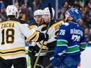 Boston Bruins' Morgan Geekie (39) celebrates his goal with Pavel Zacha (18) and David Pastrnak (88) as Vancouver Canucks' Erik Brannstrom (26) skates past during the first period of an NHL hockey game in Vancouver, Dec. 14, 2024.