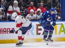 Vancouver Canucks' Brock Boeser (6) avoids a check from Florida Panthers' Niko Mikkola (77) during the third period of an NHL hockey game in Vancouver, B.C., Thursday, Dec. 12, 2024.