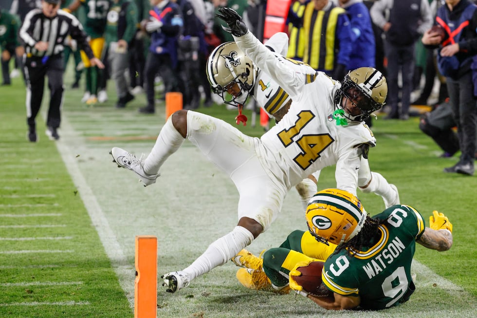 Green Bay Packers wide receiver Christian Watson (9) is knocked out of bounds by New Orleans...