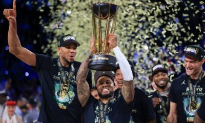 Milwaukee Bucks guard Damian Lillard (0) lifts up the NBA Cup while forward Giannis Antetokounmpo (34), left, and center Brook Lopez (11), right, celebrate after their team's victory in the championship game of the NBA Cup basketball tournament