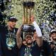 Milwaukee Bucks guard Damian Lillard (0) lifts up the NBA Cup while forward Giannis Antetokounmpo (34), left, and center Brook Lopez (11), right, celebrate after their team's victory in the championship game of the NBA Cup basketball tournament