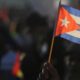 A person waves a Cuban flag during a gathering marking International Workers' Day at Anti-Imperialist Square in Havana, Cuba, May 1, 2024. (AP Photo/Ariel Ley)