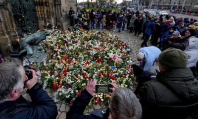 People lay flowers at the entrance of a church near a Christmas Market, where a car drove into a crowd on Friday evening, in Magdeburg, Germany, Saturday, Dec. 21, 2024. (AP Photo/Michael Probst)