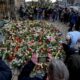 People lay flowers at the entrance of a church near a Christmas Market, where a car drove into a crowd on Friday evening, in Magdeburg, Germany, Saturday, Dec. 21, 2024. (AP Photo/Michael Probst)