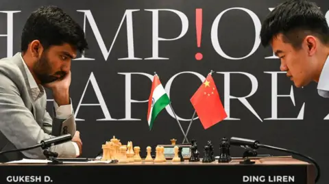 AFP China's chess grandmaster Ding Liren (R) and India's chess grandmaster Gukesh Dommaraju (L) compete during the start of the FIDE World Chess Championship in Singapore on November 25, 2024. 