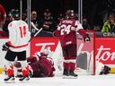 Canada's Matthew Schaefer (bottom right) lies on the ice after colliding with the Latvian net during a game at the IIHF world junior hockey championship in Ottawa on Dec. 27, 2024. 