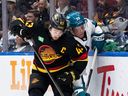 Quinn Hughes battles San Jose's Fabian Zetterlund during a game on Dec. 23.