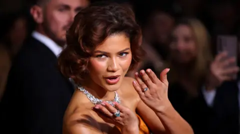 Reuters Zendaya shows off the rings on both hands as she poses on the red carpet