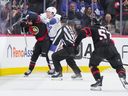 Morgan Rielly of the Toronto Maple Leafs cross-checks Ridly Greig of the Ottawa Senators in the head after his empty net goal last year.