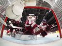 Latvia goaltender Linards Feldbergs turns to make a save against Canada with help from Martins Klaucans (right) during the first period of an IIHF world junior hockey championship preliminary round game in Ottawa on Dec. 27, 2024. 