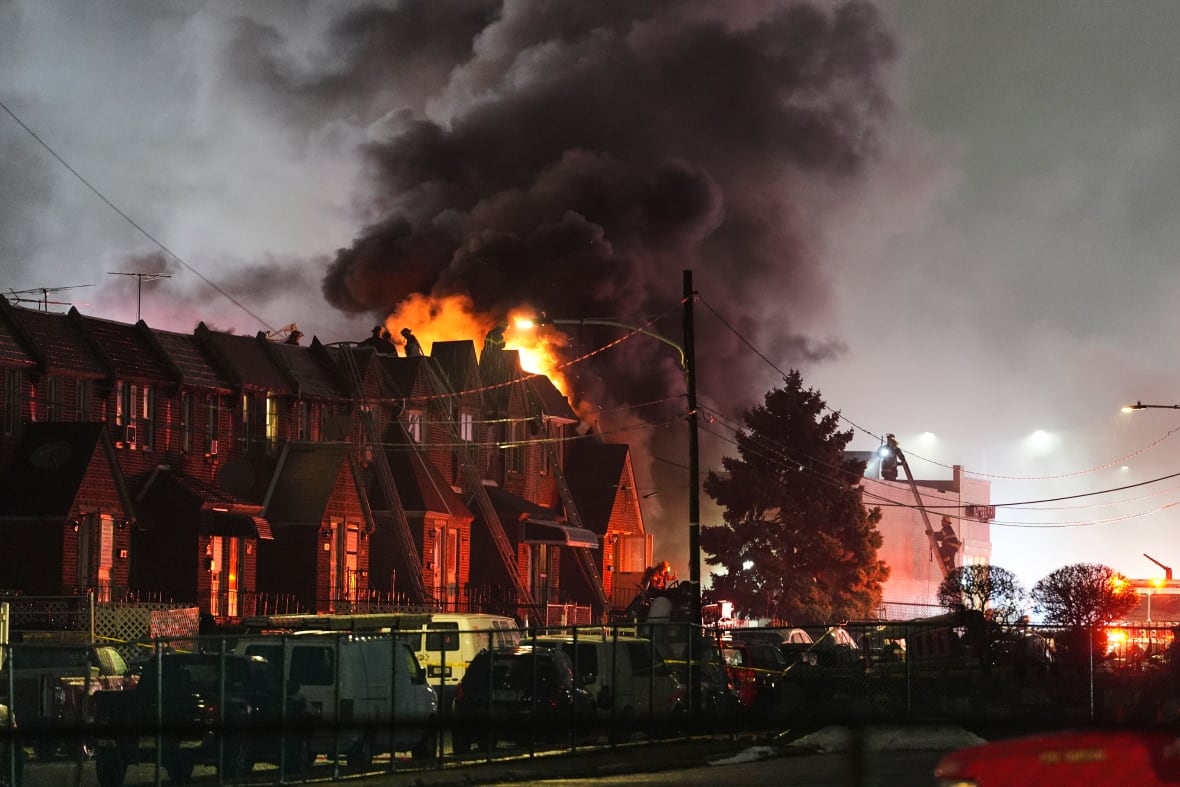 Fire and smoke are seen rising behind homes in Philadelphia following a plane crash.